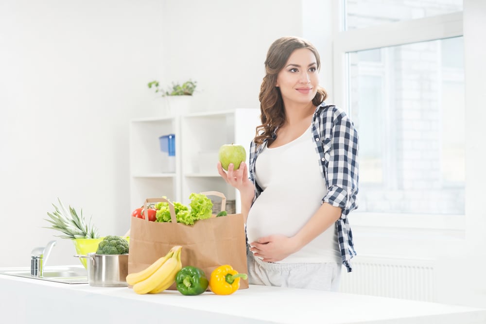 Photo of beautiful pregnant woman in the kitchen