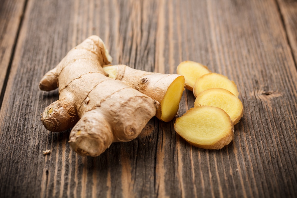 photo of sliced ginger on a wooden table which is a good remedy to cure earache