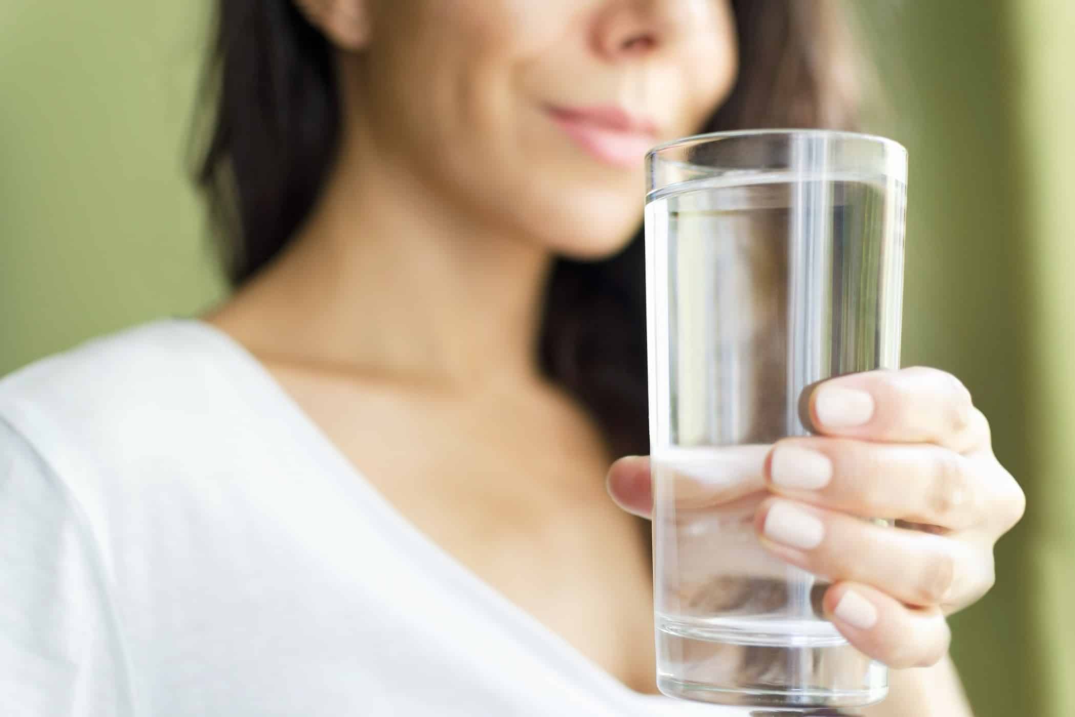 women holding a glass of water