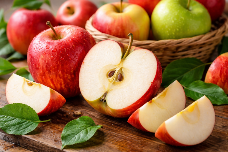 Fresh apples with dewdrops on wood